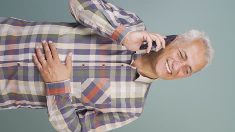Vertical-video-of-Happy-talking-man-on-the-phone.